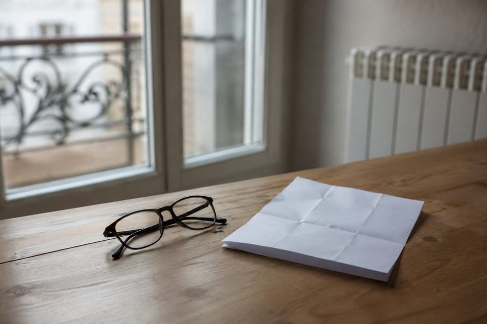 Monture de lunettes et ordonnance optique posées près d'une fenêtre